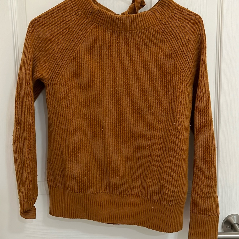 Copper colored sweater with a flirty twist. Peekaboo back with romantic tie